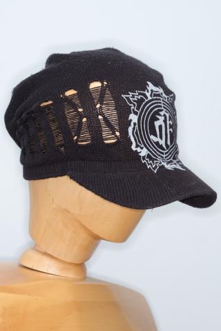 a distinctive knitted dark cap with a large white logo outlined with three circles